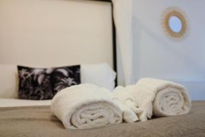 einen Haufen weißer Handtücher auf einem Bett in der Unterkunft Hotwells apartments flat 1 - Hopewell in Bristol