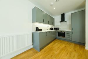 a kitchen with gray cabinets and a wooden floor at Hotwells apartments flat 6- Hopewell in Bristol