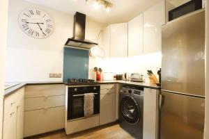 a kitchen with a stove and a clock on the wall at Cotham Vale 2 bedroom property in Bristol