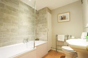a bathroom with a tub and a toilet and a sink at Cotham Vale 2 bedroom property in Bristol