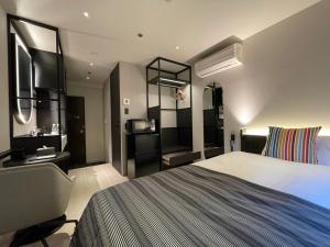 a bedroom with a bed and a desk and a television at Hotel Sunroute Kumamoto in Kumamoto