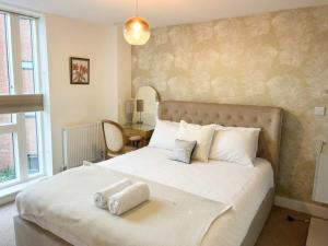 a bedroom with a large bed with white pillows at Cooperage 3 bedroom house in Bristol