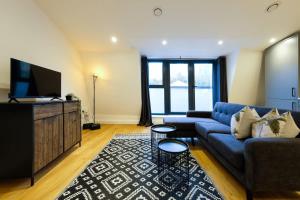 a living room with a blue couch and a flat screen tv at Hotwells apartments flat 7- Hopewell in Bristol