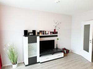 ein Wohnzimmer mit einem TV an einer weißen Wand in der Unterkunft Haus Nordseeblick Wohnung 9 in Büsum