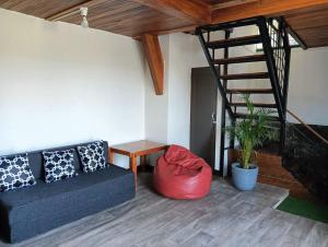 a living room with a couch and a spiral staircase at Procycling Tours in Shillong