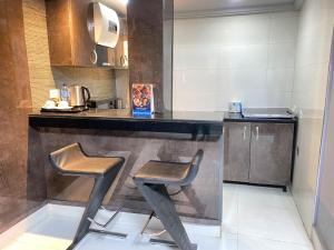 uma cozinha com dois bancos e um balcão num quarto em Newland Luxury Hotels and Apartments em Abuja