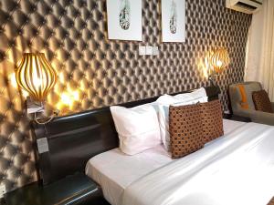 a hotel room with a bed with a headboard at Newland Luxury Hotels and Apartments in Abuja