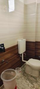 a bathroom with a white toilet in a room at Hotel Sunshine in Katra
