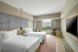 a hotel room with two beds and a flat screen tv at Radisson Hotel Sector 29 Gurugram in Gurgaon +20 photos