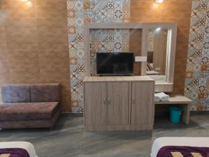 a hotel room with a tv and a mirror at Hotel Sunshine in Katra