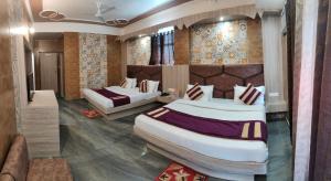 a hotel room with two beds in a room at Hotel Sunshine in Katra