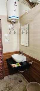 a bathroom with a sink and a mirror at Hotel Sunshine in Katra