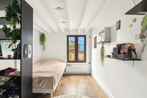 a small room with a bed and a window at Charmant Triplex familial du canal de Saint-Martin by Weekome in Paris