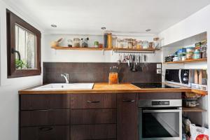 a kitchen with a sink and a stove at Charmant Triplex familial du canal de Saint-Martin by Weekome in Paris