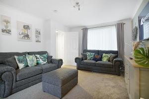 a living room with two couches and a tv at Deerness Viewpoint-Your Scenic Retreat in Brandon in Durham