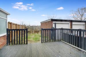 una terraza de madera con una valla y un garaje en Deerness Viewpoint-Your Scenic Retreat in Brandon en Durham