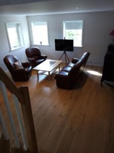 Sala de estar con 2 sillas de cuero y mesa de centro en Gula huset en Gotemburgo