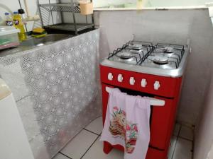 a kitchen with a red stove with towels on it at Kitnet aconchegante in Olinda +3 photos