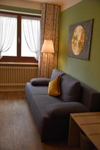 a living room with a couch and a window at Pension Langerspacher in Grabenstätt