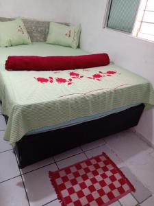 een bed in een kamer met een geruite vloer bij Kitnet aconchegante in Olinda