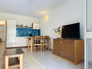 uma sala de estar com televisão e uma cozinha em Wind - Apartments close to the beach em Santa Maria