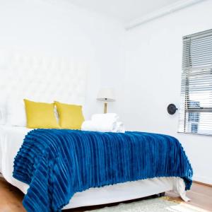 Johannesburg的住宿－The Westpoint Penthouse on 12th floor，白色房间床上的蓝色毯子