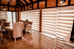 a room with two chairs and a table and blinds at Lux Villa Emina in Tuzla