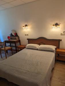 1 dormitorio con 1 cama grande y 1 mesa en Auberge Des Pins, en Aubenas