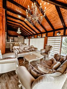 a living room with couches and a chandelier at Lux Villa Emina in Tuzla