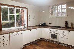 a kitchen with white cabinets and a stove top oven at Casa a piorneira in Teo