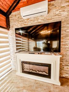 a fireplace with a tv on a brick wall at Lux Villa Emina in Tuzla +117 photos