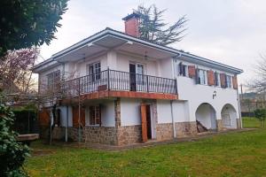 a large white house with a balcony on top at Casa a piorneira in Teo