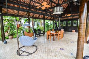 a patio with a table and chairs and a swing at Cocoville Phuket - SHA Plus in Chalong 
