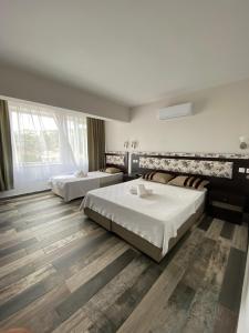 a bedroom with two beds and a large window at Denge Pansiyon in Kaş