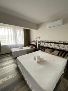a hotel room with two beds and a window at Denge Pansiyon in Kaş