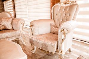 a pair of white chairs in a room at Lux Villa Emina in Tuzla