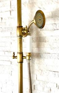 a shower with a shower head on a wall at Zenit Olhao Bed & Breakfast in Olhão