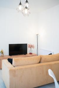 a living room with a couch and a flat screen tv at El Rincón de Alquézar in Alquézar