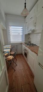 コンスタンツァにあるNeverSea Apartmentの白いキャビネット、シンク、テーブル付きのキッチンが備わります。