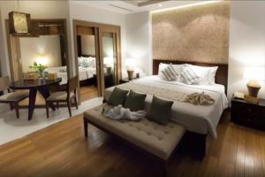 a bedroom with a large bed and a dining room at The Cliff Residence in Mui Ne