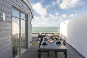 una mesa en un balcón con vistas al océano en 66 Pentire, Newquay en Newquay