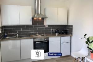 a kitchen with white cabinets and a stove at Netley Village Apartment By Your Stay Solutions Short Lets & Serviced Accommodation Netley Southampton With Free Wi-Fi in Southampton