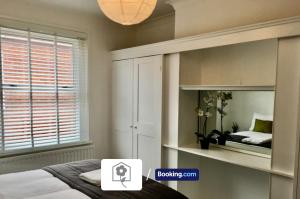 a bedroom with a bed and a window with a mirror at Netley Village Apartment By Your Stay Solutions Short Lets & Serviced Accommodation Netley Southampton With Free Wi-Fi in Southampton