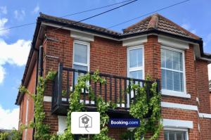 a red brick house with a balcony at Netley Village Apartment By Your Stay Solutions Short Lets & Serviced Accommodation Netley Southampton With Free Wi-Fi in Southampton