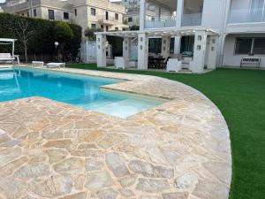 una piscina con prato verde accanto a un edificio di Casa de lidzia2 a Cisternino