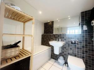 een badkamer met een wastafel, een bad en een toilet bij The Robinson Building in Bristol