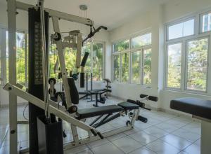 a gym with tread machines in a room with windows at The White House Opp Park Hyatt in Chennai