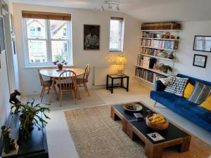 uma sala de estar com um sofá azul e uma mesa em One bedroom flat in Cambridge court em Bristol