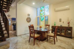 a dining room with a table and chairs and a window at The White House Opp Park Hyatt in Chennai