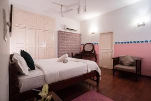um quarto com uma cama grande e uma cadeira em The White House Opp Park Hyatt em Chennai